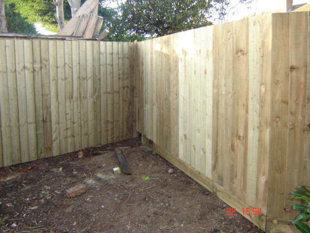 Feather board fence with wooden posts and kickboards in Chipping Norton